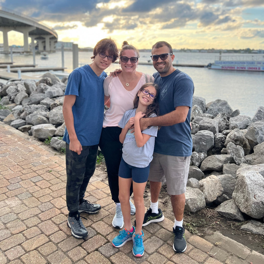 Family photo of Gabriela with her son Daniel, husband Gustavo, and daughter Marina, smiling together outdoors.